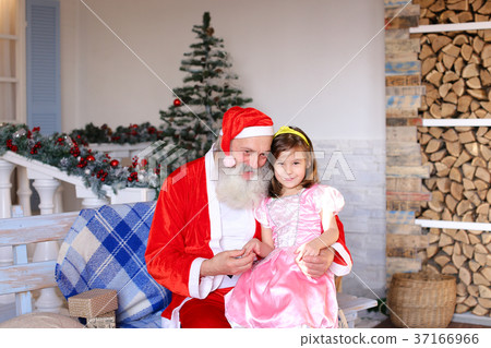 Cheerful Santa Claus talking to little girl. 37166966