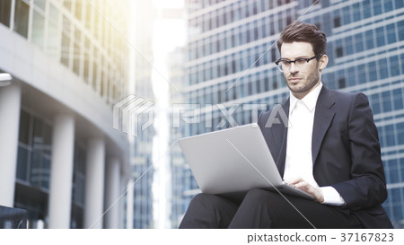 Front view of a handsome young businessman working Front view of a handsome young businessman working 37167823