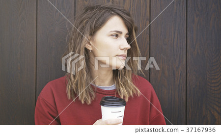 Portrait of young woman wearing a red sweater is 37167936