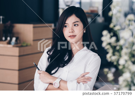 confident businesswoman standing with arms crossed at office. young female entrepreneur woman smiling at workplace. working, business concept 37170799