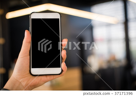 mockup image of hand holding smartphone in cafe restaurant. mobile phone with blank white screen in coffee shop. mockup image of hand holding smartphone in cafe restaurant. mobile phone with blank white screen in coffee shop. 37171396