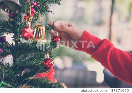 woman holding xmas ornament. girl decorate Christmas tree in a house. holiday celebration. 37171650