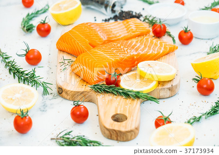 Raw and fresh salmon meat fillet on wooden cutting board Raw and fresh salmon meat fillet on wooden cutting board 37173934