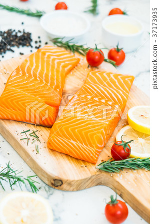 Raw and fresh salmon meat fillet on wooden cutting board Raw and fresh salmon meat fillet on wooden cutting board 37173935
