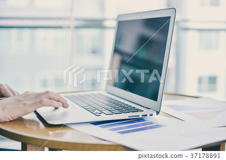 Close up hand touching a laptop in business concept with free sp 37178891