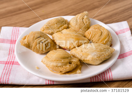 Curry puff snacks on white dish with wood Curry puff snacks on white dish with wood 37181529