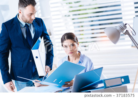 Strict woman holding a folder and looking Strict woman holding a folder and looking 37183575