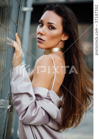 Fashion portrait of a sexy girl in a coat and 37187302