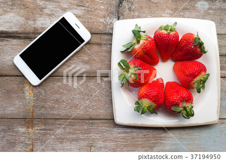 Fresh strawberries in a dish and Phone Fresh strawberries in a dish and Phone 37194950