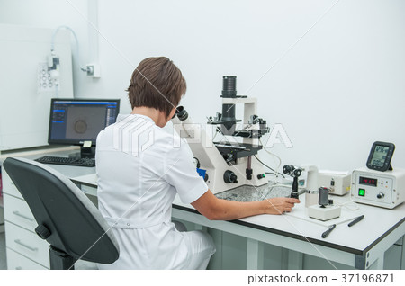 medical researcher looking through microscop medical researcher looking through microscop 37196871