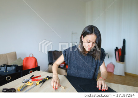 Girl showing how to make leather purse. 37197284