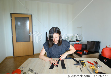 Student learning to sew zipper on purse. 37197446