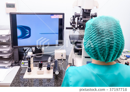 Embryologist adding sperm to egg in laboratory  37197718