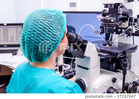 Embryologist adding sperm to egg in laboratory  37197847