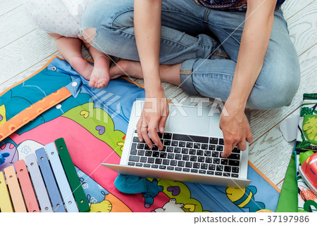 young mother working on laptop with toddler child young mother working on laptop with toddler child 37197986