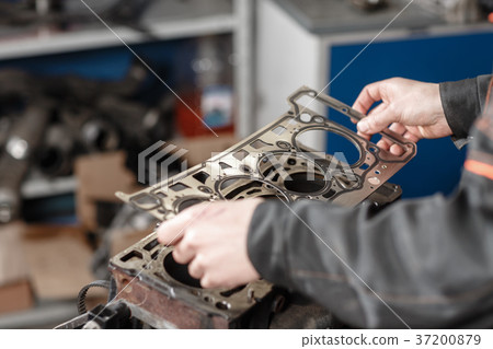 Sealing gasket in hand. The mechanic disassemble Sealing gasket in hand. The mechanic disassemble 37200879
