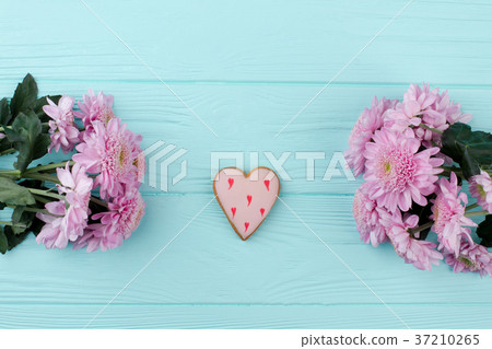 Heart shaped cookie and chrysanthemums. 37210265