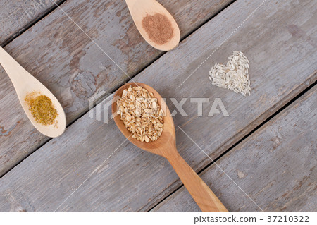 Wooden spoon with oat flakes. Wooden spoon with oat flakes. 37210322