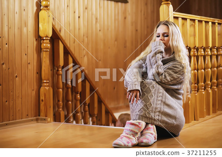 A young girl sits on a ladder in a sweater 37211255