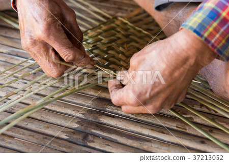 Old man hands manually weaving bamboo. 37213052