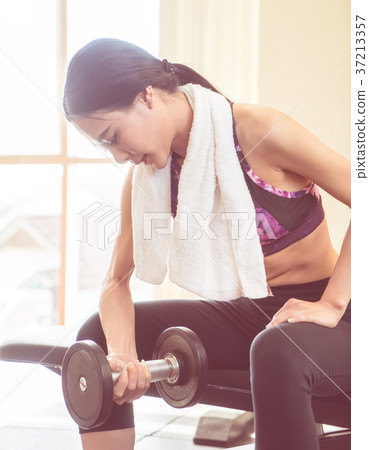 Strong woman is lifting dumbbell workout 37213357