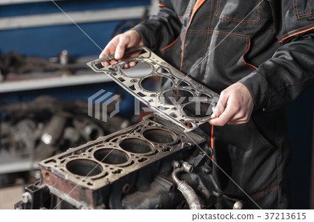 Sealing gasket in hand. The mechanic disassemble Sealing gasket in hand. The mechanic disassemble 37213615
