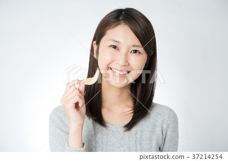 A woman eating potato chips A woman eating potato chips 37214254