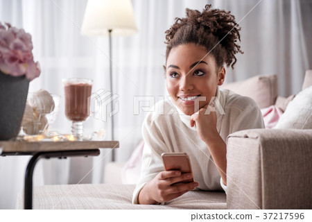 Dreamful african girl relaxing on couch with 37217596