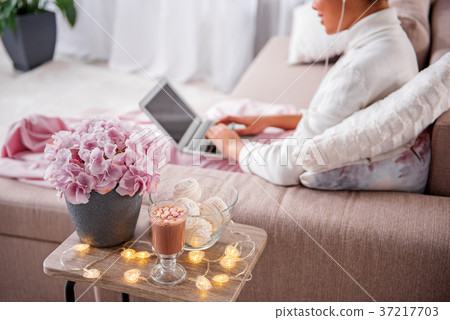 Hot beverage and zephyr with flowerpot on desk 37217703
