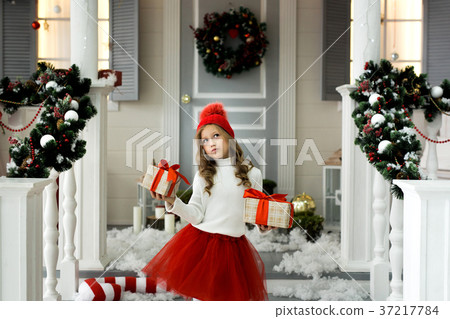 Happy little girl holding a lot of boxes with 37217784
