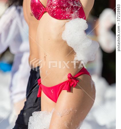 Youth at a foamy party on the beach 37218983