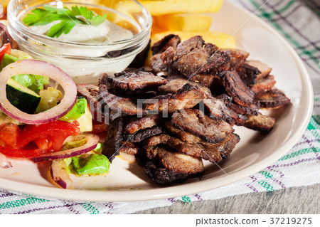 Grilled meat with French fries and vegetables 37219275