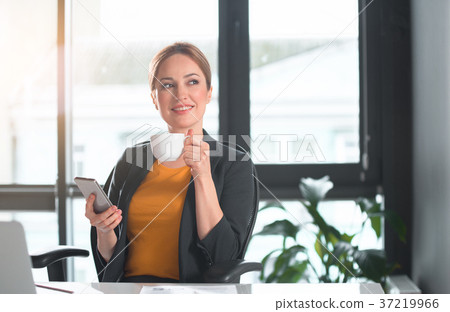 Cheerful lady drinking mug of beverage Cheerful lady drinking mug of beverage 37219966