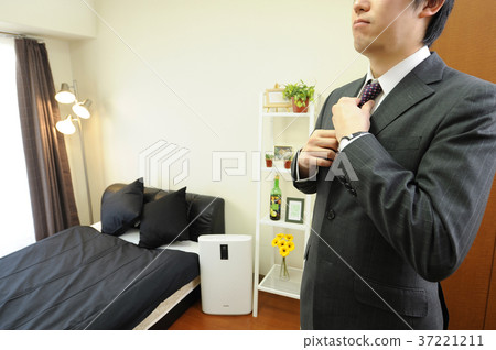Office worker closing a tie in a room Office worker closing a tie in a room 37221211