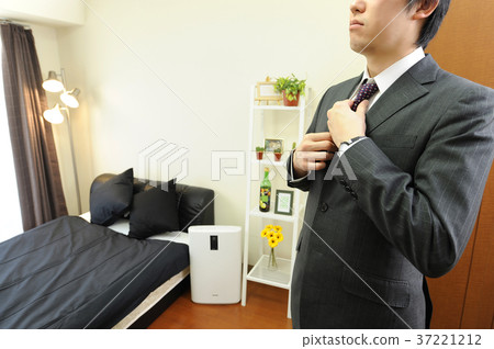 Office worker closing a tie in a room Office worker closing a tie in a room 37221212