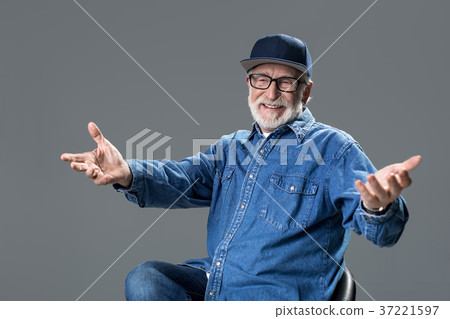 Smiling bearded old man sitting on chair 37221597