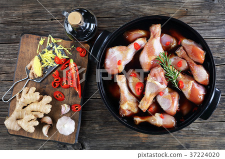 raw chicken drumsticks in black pot raw chicken drumsticks in black pot 37224020