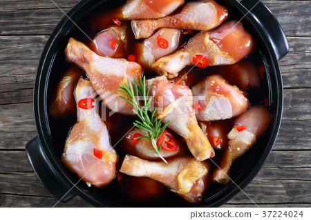 raw chicken drumsticks in a black pot raw chicken drumsticks in a black pot 37224024