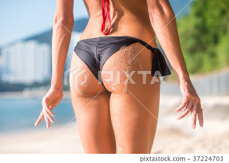 Sporty female butt in with two sand hand prints 37224703