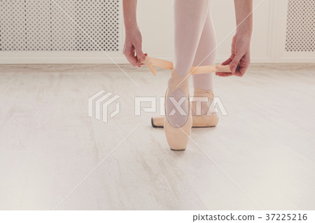 Ballerina puts on pointe ballet shoes, graceful Ballerina puts on pointe ballet shoes, graceful 37225216