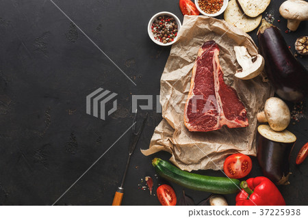 Raw t-bone steak on craft papper on dark 37225938