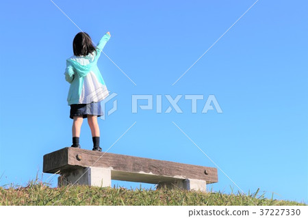 Girl pushing her fist towards the sky Girl pushing her fist towards the sky 37227330
