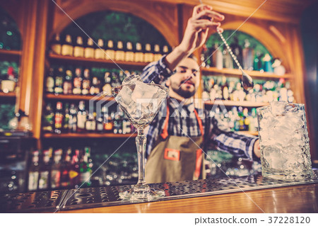 Barman making an alcoholic cocktail at the bar Barman making an alcoholic cocktail at the bar 37228120