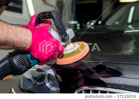 A man polishes a black car 37228839