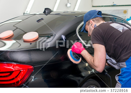 A man polishes a black car A man polishes a black car 37228916