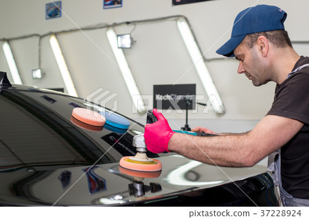 A man polishes a black car 37228924