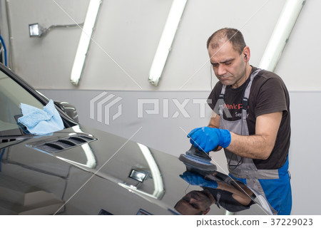 A man polishes a black car 37229023