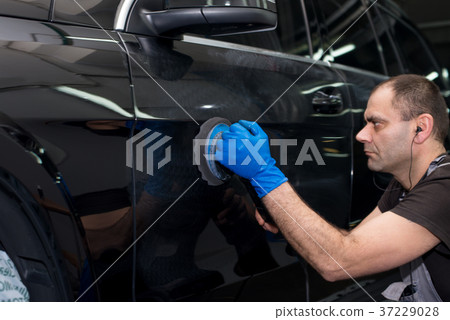 A man polishes a black car 37229028