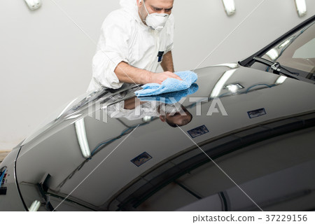 Man on a car wash polishing car with a polish machine Man on a car wash polishing car with a polish machine 37229156
