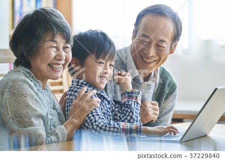 A grandchild who does a personal computer and a senior who sees it 37229840